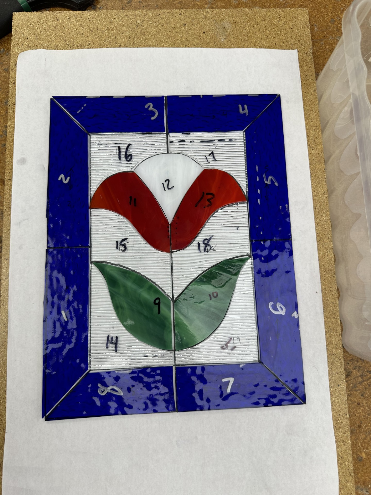Small stained glass window depicting a tulip in progress